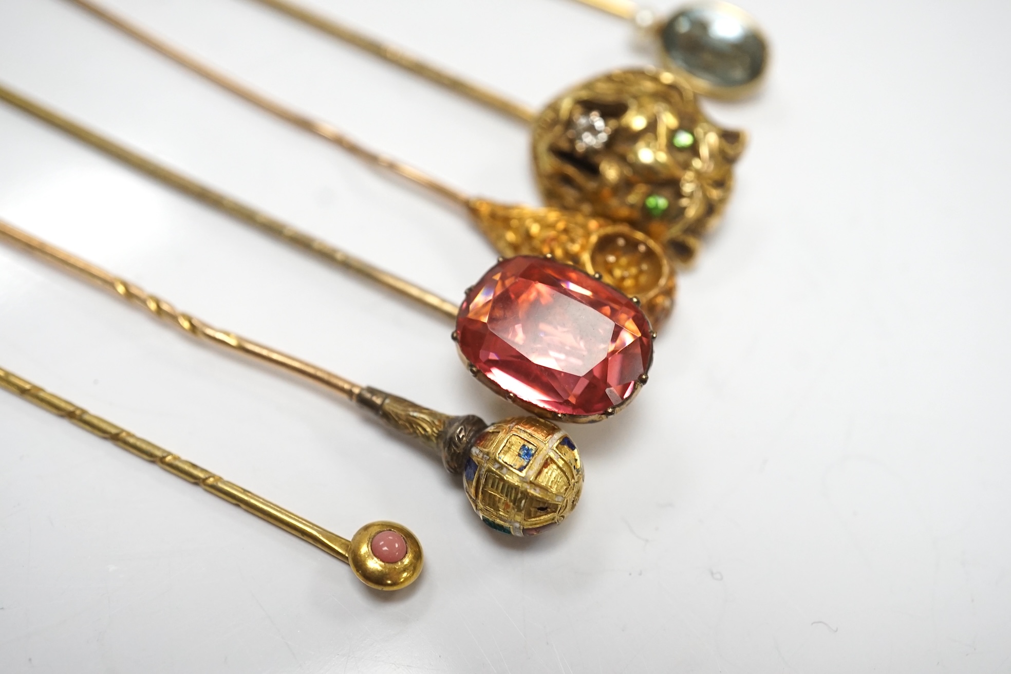 A collection of six assorted mainly early 20th century stick pins including tiger's head set with diamond and green garnets, 68mm. Condition - poor to fair